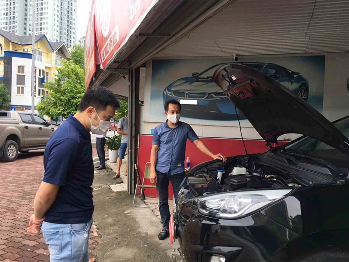 Alt: Hình ảnh một người đang kiểm tra tình trạng của chiếc xe ô tô trước khi thuê