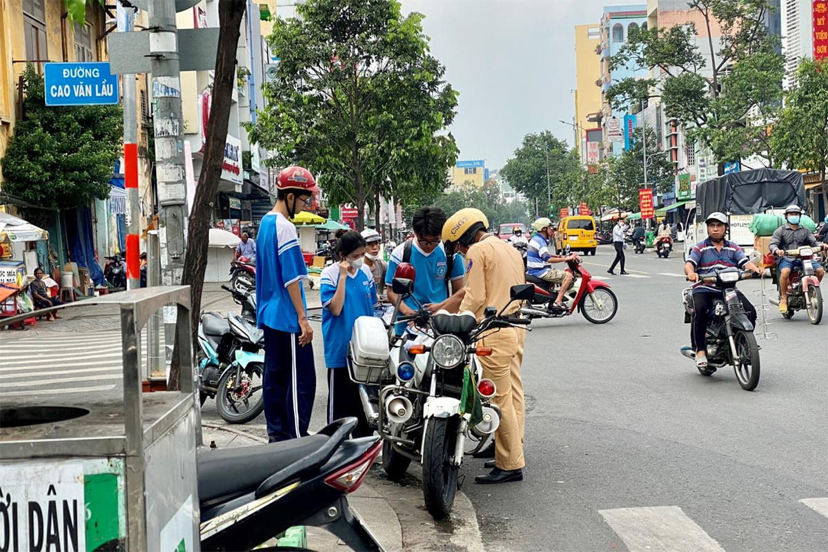Alt text: Người điều khiển xe cơ giới xuất trình giấy tờ cho cảnh sát giao thông.