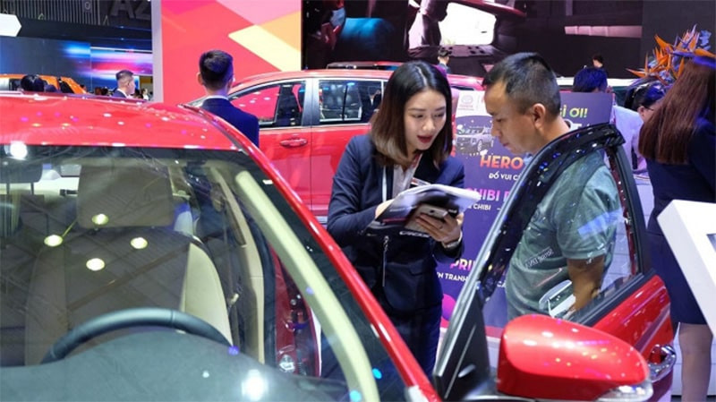 Nam 1977 bên cạnh xe ô tô màu đỏ